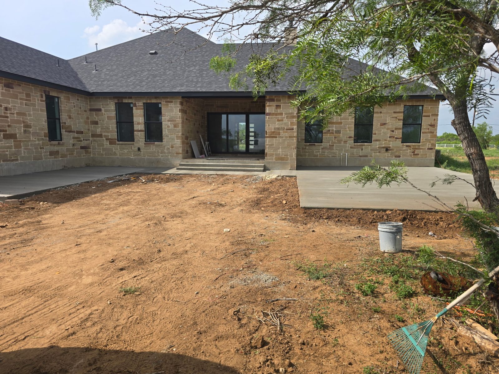 Finished stone-front home with new shingle roof and poured concrete patio