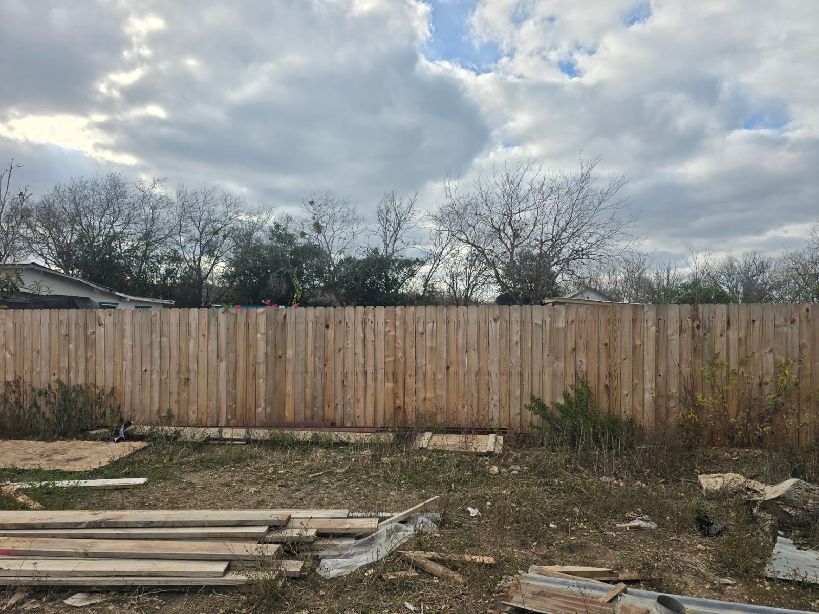 New wood privacy fence running the length of a backyard