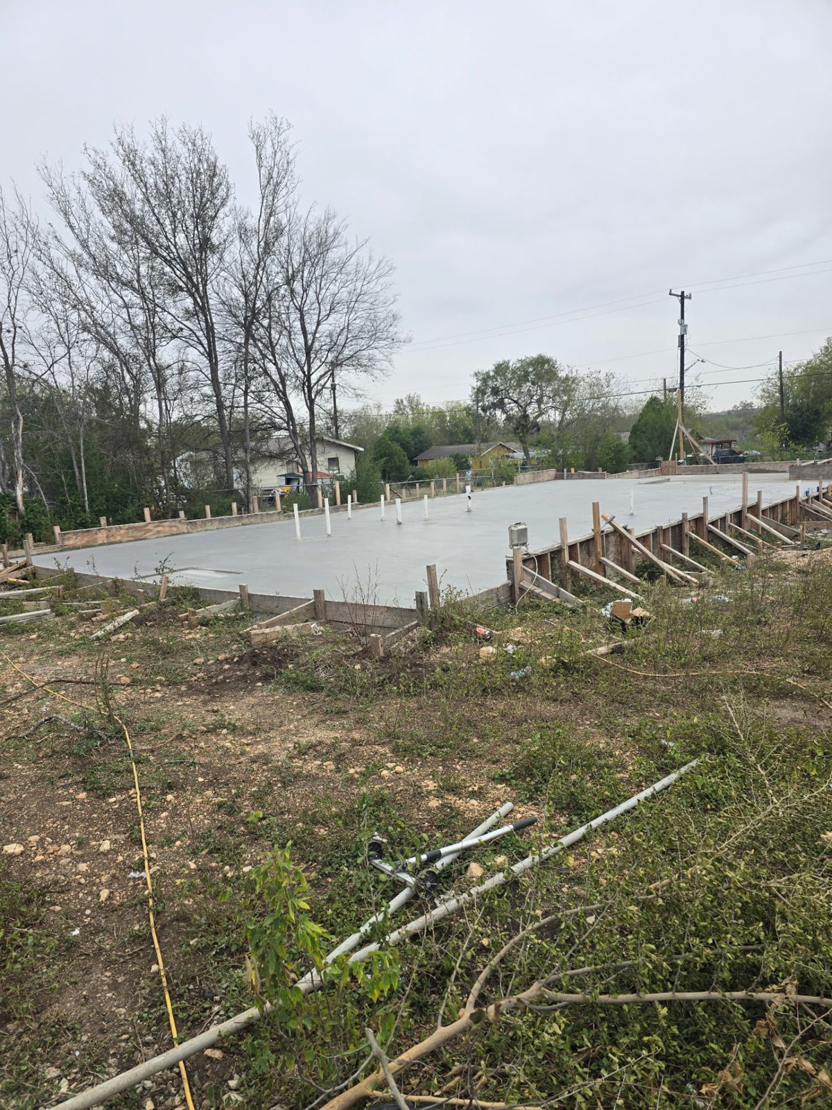 Freshly poured concrete foundation slab with forms and plumbing stub-outs